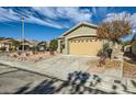 House exterior featuring a two-car garage and desert landscaping at 10282 Country Flats Ln, Las Vegas, NV 89135