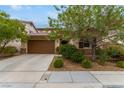 One-story house with brown garage door, landscaping, and a tree at 1172 Via Della Costrella, Henderson, NV 89011