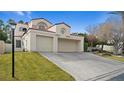 Two-story house with attached two-car garage and grassy front yard at 2107 Inverness Dr, Henderson, NV 89074