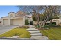 Two-story house with attached two-car garage and stone pathway at 2107 Inverness Dr, Henderson, NV 89074