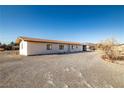 A single-story home with a desert landscape, gravel yard, and a metal roof at 3381 W Simkins Rd, Pahrump, NV 89060