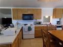 Kitchen with wood cabinets, white appliances, and an island at 3381 W Simkins Rd, Pahrump, NV 89060