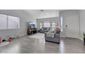 Bright living room with gray couches, hardwood floors, and large windows at 4722 Casa Bonita Dr, North Las Vegas, NV 89032