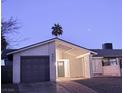 Well-kept single-story home with a gray garage door, stucco walls, and desert landscaping at 4928 Nellie Springs Ct, Las Vegas, NV 89110