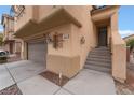 Beige two-story house with attached garage and stairs leading to the front entrance at 5916 Magic Oak St, North Las Vegas, NV 89031