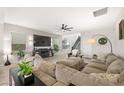 Inviting living room featuring a large sectional sofa, ceiling fan, and modern decor at 7073 Range Valley St, North Las Vegas, NV 89084