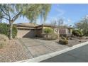 Attractive single-story home featuring a desert landscape, a well-maintained driveway, and an attached garage at 7288 Olsen Farm St, Las Vegas, NV 89131