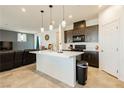 Modern kitchen with a large island, pendant lighting, and stainless steel appliances at 1004 Huckburn Ave, Henderson, NV 89015