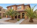 Inviting two-story home featuring a covered entryway with columns and desert landscaping at 1067 Via Saint Andrea Pl, Henderson, NV 89011