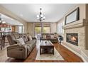 Cozy living room with hardwood floors, a stone fireplace, and comfortable seating at 1067 Via Saint Andrea Pl, Henderson, NV 89011