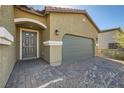 Close-up of the home's front entrance, featuring an elegant walkway and a gray garage door at 10923 Stone Crossing Ave, Las Vegas, NV 89166