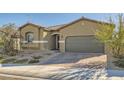 Single story home featuring a two-car garage and low maintenance desert landscaping at 10923 Stone Crossing Ave, Las Vegas, NV 89166