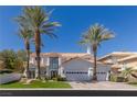 Luxury home with white exterior, palm trees, and a three-car garage at 1613 Iron Ridge Dr, Las Vegas, NV 89117