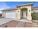 House exterior with attached garage and a landscaped walkway to the entrance at 1920 Cavalry St, Pahrump, NV 89048