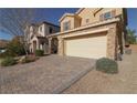 Front view of the house with a brick paved driveway and landscaping at 242 Botanic Gardens Dr, Las Vegas, NV 89148