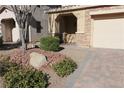 Landscaped front yard with a brick walkway and large rock accents at 242 Botanic Gardens Dr, Las Vegas, NV 89148