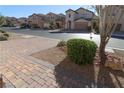 Landscaped front yard with a brick walkway and neighborhood view at 242 Botanic Gardens Dr, Las Vegas, NV 89148