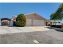 View of the home's exterior, showcasing a three-car garage and driveway at 303 Glasgow St, Henderson, NV 89015