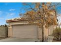 Two-story house with beige siding, attached garage, and a tree in the front yard at 3968 Moon Tango St, Las Vegas, NV 89129