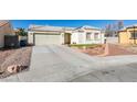 Front view of a house with a driveway, garage, and neatly kept landscaping at 5417 Lemhi Ct, North Las Vegas, NV 89031