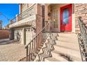 Close up of home's entrance with ornate red door, brickwork, and iron railing at 5490 Tulip Hill Ave, Las Vegas, NV 89141