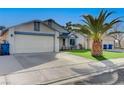 Single story home with synthetic grass, complemented by a palm tree and a clean two car driveway at 5767 Tabitha Ave, Las Vegas, NV 89156