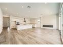 Open-concept living space with wood floors, modern fireplace, recessed lights, and access to the kitchen at 65 Ibiza Lake Dr, Henderson, NV 89011