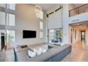 Contemporary living room featuring high ceilings, an oversized sectional sofa and a large wall mounted television at 2680 Mystere Ct, Las Vegas, NV 89117