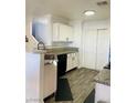 Kitchen with granite countertops, white cabinets, and wood-look floors at 3495 Greenwood Springs Dr, Las Vegas, NV 89122