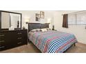 Comfortable bedroom with a double bed, dresser, and striped bedding at 3982 Voxna St, Las Vegas, NV 89119