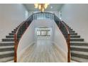 Elegant double staircase with wrought iron railings and wood accents at 7024 Bluebird Wing St, North Las Vegas, NV 89084