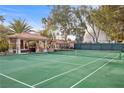 Well-maintained backyard tennis court with covered seating area at 7450 Via Olivero Ave, Las Vegas, NV 89117