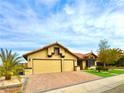 Two-car garage with a brick paved driveway and desert landscaping at 7874 Clearwood Ave, Las Vegas, NV 89123