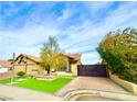 Landscaped front yard with a modern gate and paved driveway at 7874 Clearwood Ave, Las Vegas, NV 89123