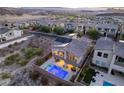 An aerial view of the home showing a pool, solar panels and the surrounding community at 8 Hilltop Crest St, Henderson, NV 89011