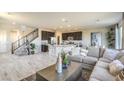 Open concept living and kitchen area with gray sectional sofa and hardwood floors at 8406 Sycamore Creek St, Las Vegas, NV 89113