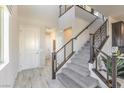 Modern staircase with gray carpet, dark wood railing, and light flooring at 8406 Sycamore Creek St, Las Vegas, NV 89113