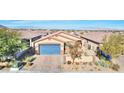 One-story house with blue garage door and desert landscaping at 1290 El Solindo Ln, Henderson, NV 89002