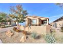 Tan house with blue garage door and drought-tolerant landscaping at 1290 El Solindo Ln, Henderson, NV 89002
