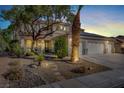 Two-story house with three-car garage, palm tree, and nighttime lighting at 1306 Big Tree Ave, North Las Vegas, NV 89031