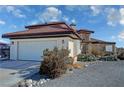 Attached two-car garage with light-colored door and landscaping at 3821 S Tumbleweed Ave, Pahrump, NV 89048