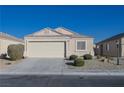 Front view of a tan house with a two-car garage and small front yard at 5916 Naperville St, Las Vegas, NV 89130