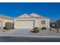 Tan colored house with a two-car garage and neatly landscaped yard at 5916 Naperville St, Las Vegas, NV 89130