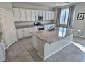 Modern kitchen featuring white cabinets, stainless steel appliances, and a spacious granite island at 7733 Rosebark Cliffs St, North Las Vegas, NV 89084