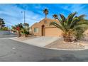 Tan house with a two-car garage and palm trees at 7908 Mountain Point Ave, Las Vegas, NV 89131