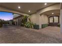 Covered driveway featuring detailed brickwork, lush greenery, and convenient access to the home's entrance at 10000 Cresent Mesa Ln, Las Vegas, NV 89145