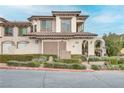 Two-story townhome with Mediterranean styling, landscaped grounds, and attached garage at 19 Via Visione # 204, Henderson, NV 89011