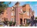 Two-story townhome with a Spanish architectural style, showcasing light orange and mauve colors at 3975 N Hualapai Way # 266, Las Vegas, NV 89129