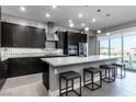 Modern kitchen boasts dark cabinets, stainless steel appliances, a spacious island with seating, and backyard views at 4269 Solace St # 0, Las Vegas, NV 89135