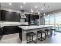 Modern kitchen features a large island with seating, stainless steel appliances, and stylish backsplash at 4269 Solace St # 0, Las Vegas, NV 89135